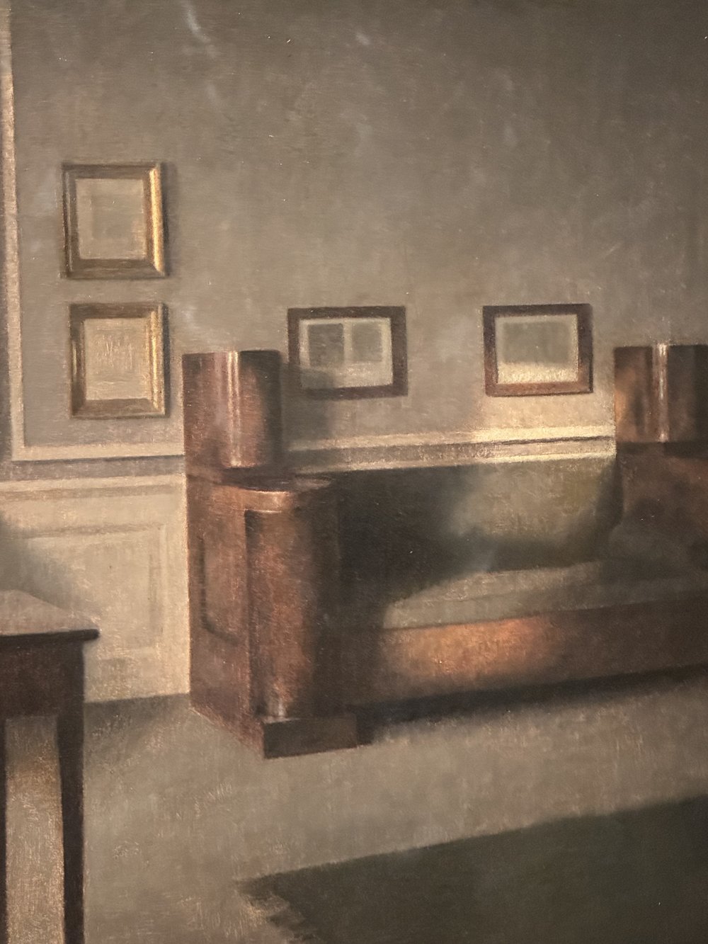 Vilhelm Hammershøi, Interior ensolarado: sala silenciosa com sofá, quadros na parede e luz suave